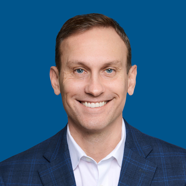 Headshot of Peter Norman, blue background