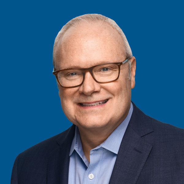 Headshot of Thomas Harvey, blue background