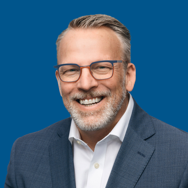 Headshot of James Schoener, blue background