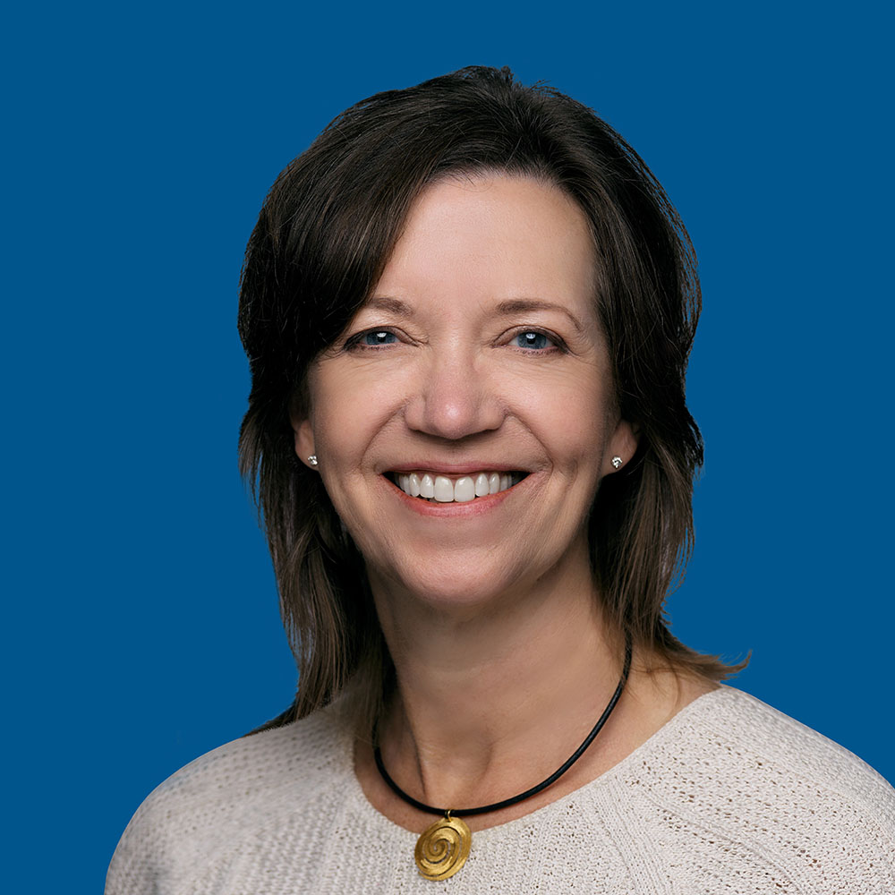 Headshot of Julie Lekstrom Himes, blue background