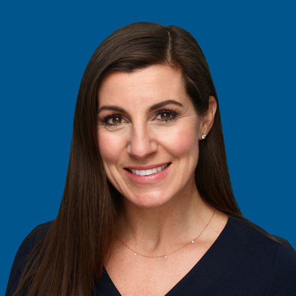 Headshot of Sandy Coombs, blue background