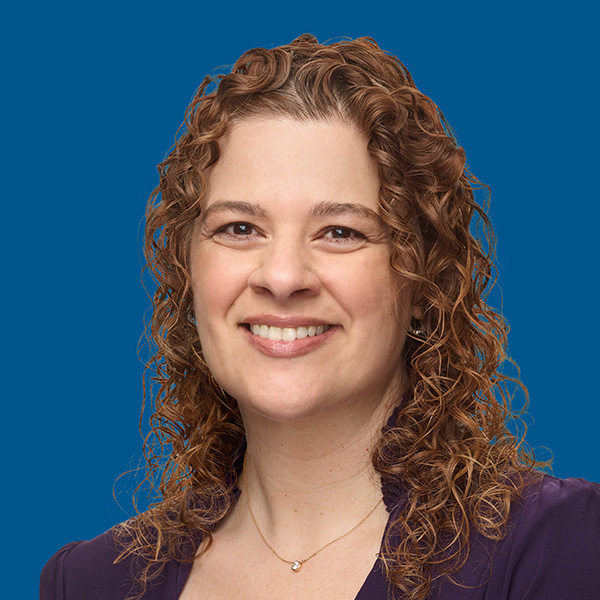 Headshot of Colleen Ellwanger, blue background