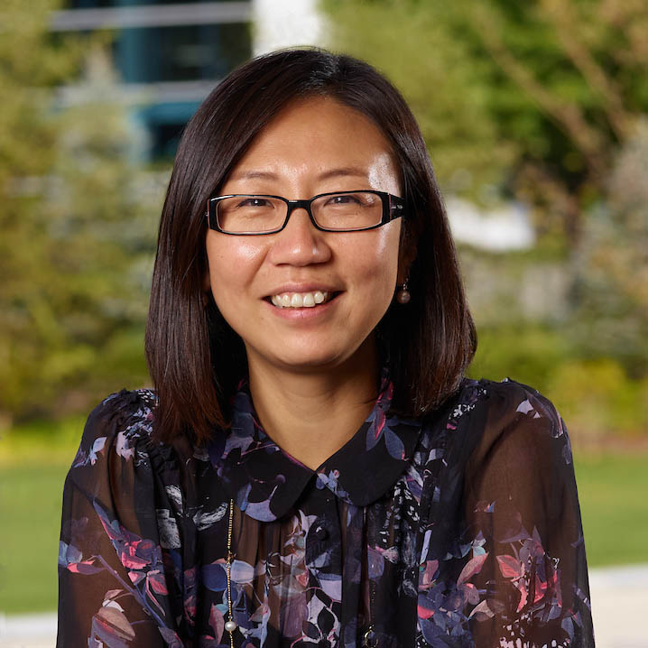 Smiling woman in grey shirt sitting in red conference room at Alkermes