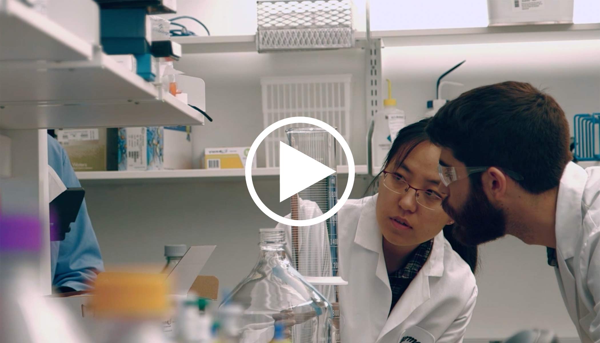 alkermes employees in white lab coats view beaker