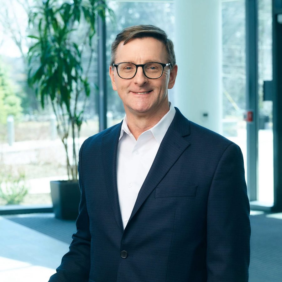Jim McGrory standing up waring a blue suit jacket and white shirt