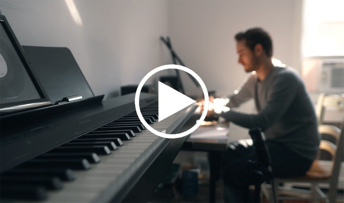 man sitting at piano keyboard