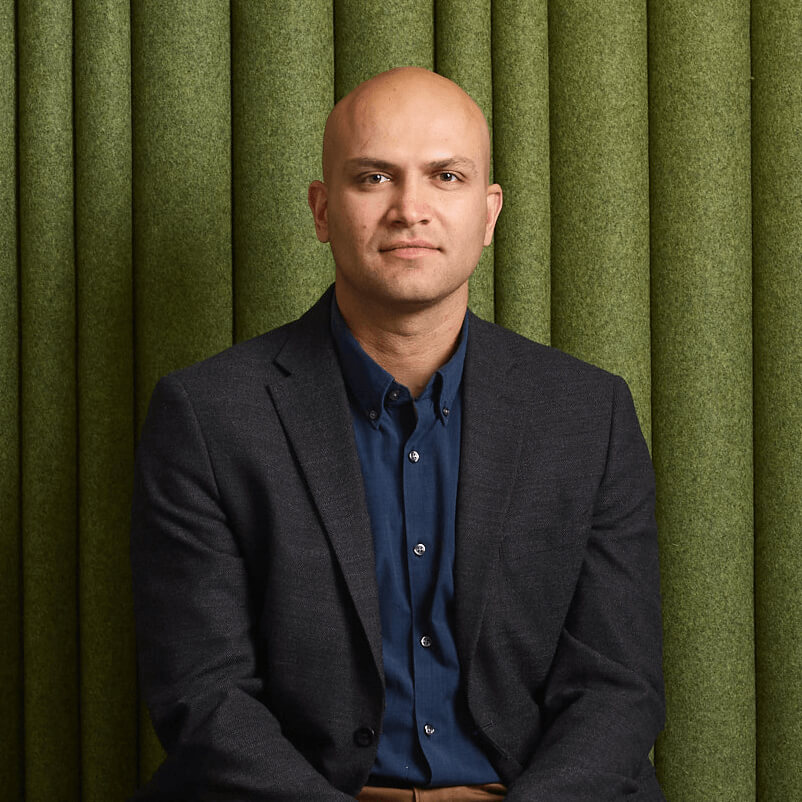 Man sitting in front of green background at Alkermes office.